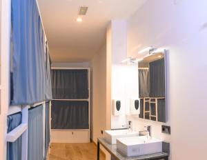 a bathroom with two sinks and a mirror at VAD HOSTEL ALICANTE in Alicante