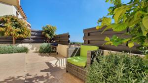 un patio con una sedia verde e alcune piante di Dafni villa 9 a Paralimni