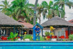 a man sitting on a blue statue next to a swimming pool at Best Western Jangwani Sea Breeze Resort in Dar es Salaam