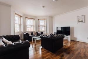 uma sala de estar com mobiliário de couro e uma televisão de ecrã plano em Top quality beach front apartment sleep up to 7 guests em Bournemouth