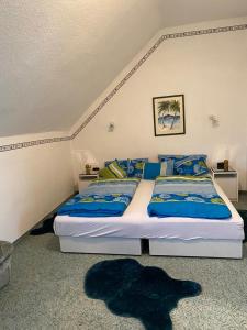 Galambok的住宿－Györe Vendégház Galambok，一间卧室配有两张带蓝色和黄色枕头的床