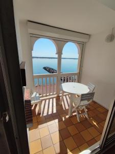 een balkon met een tafel en stoelen bij T2C sympa vue splendide in Le Barcarès