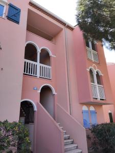 een roze huis met een trap ervoor bij T2C sympa vue splendide in Le Barcarès