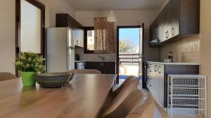 una cucina con tavolo in legno e frigorifero di Dafni villa 9 a Paralimni