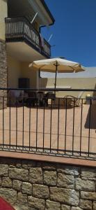 a balcony with a table and two umbrellas at Lungomare Bed rooms in Santa Maria Navarrese