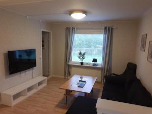 een woonkamer met een bank, een tv en een tafel bij Brofors in Forsheda