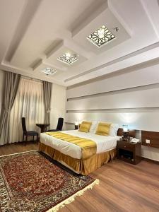 a bedroom with a large bed and a desk and a table at فندق الليالي الحالمة in Al Madinah