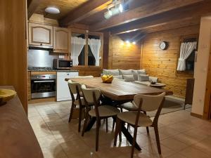 cocina y comedor con mesa de madera y sillas en Cabaña de madera Vall D Incles Parking y Wifi Gratis, en Incles