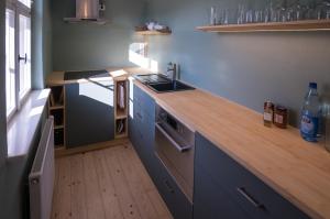 cocina con encimera de madera y fregadero en Holiday in quiet quarter, 20 min to city center, en Dresden