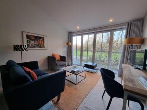 a living room with a couch and chairs and a television at THUERS IM BUSCH - Gute Stube - ab 3 Nächte - Ferienwohnungen mit Stil in Münster in Münster