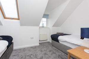 1 dormitorio con 2 camas y mesa en Main Street Town House, en Leyland