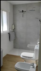a bathroom with a toilet and a glass shower at La casa de Leones in Peniscola