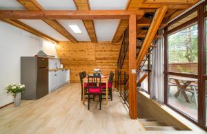 a kitchen and dining room with a table and chairs at Krasne Domki in Krasnobród +16 photos