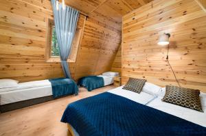 a bedroom with two beds in a log cabin at Krasne Domki in Krasnobród