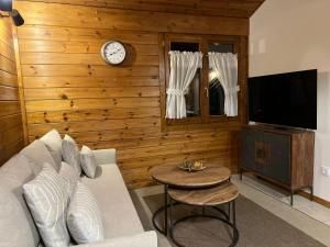 a living room with a couch and a clock on a wall at Cabaña de madera Vall D Incles Parking y Wifi Gratis in Incles