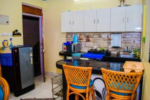 a kitchen with a counter with chairs and a refrigerator at Dona Rosa Holiday Apartment in Varca
