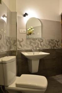 a bathroom with a toilet and a sink and a mirror at Neo Bay Hotel in Weligama