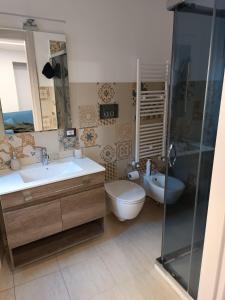 a bathroom with a toilet and a sink and a shower at La casa in piazzetta in Enna