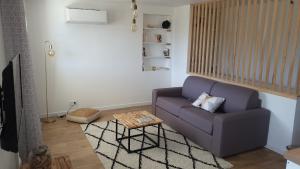 a living room with a purple couch and a table at Studio Venaco Centre Corse in Venaco
