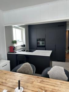 a kitchen with white cabinets and a table and chairs at Lofoten Kabelvåg-small apartment in Kabelvåg