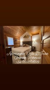 1 dormitorio con 1 cama en una habitación con paredes de madera en Cabaña de madera Vall D Incles Parking y Wifi Gratis, en Incles