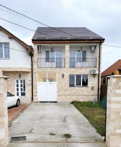 une maison avec une porte blanche et une allée. dans l'établissement Twin Room - House of Chess, à Satu Mare