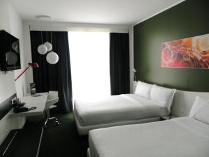 a hotel room with two beds and a window at Idea Hotel Milano Malpensa Airport in Case Nuove