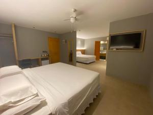 a bedroom with two beds and a flat screen tv at Mayfair Resort in Panglao Island