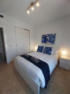 a bedroom with a large white bed with blue pillows at Albir Azul in Albir