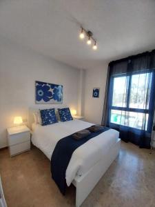 a bedroom with a large white bed and a window at Albir Azul in Albir