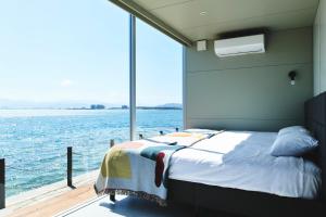 uma cama num barco com vista para a água em INN THE PARK Fukuoka em Fukuoka