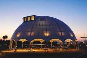 ein gewölbtes Gebäude mit Tischen und Stühlen in der Unterkunft INN THE PARK Fukuoka in Fukuoka