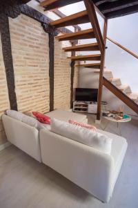 un divano bianco in una stanza con un muro di mattoni di San Cipriano House a Toledo