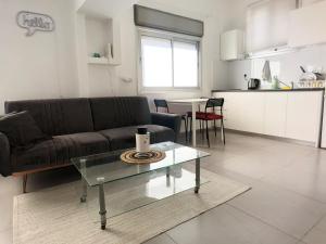 a living room with a couch and a glass table at Lev Florentin Apartments in Tel Aviv