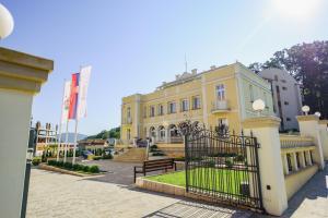 a yellow building with a gate in front of it at Vila Palas in Vrnjačka Banja