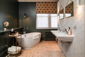 La salle de bains est pourvue d'une baignoire, de 2 lavabos et d'une fenêtre. dans l'établissement The Ginger Pig, à Brighton et Hove