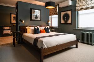 um quarto com uma cama grande e almofadas laranja em The Ginger Pig em Brighton & Hove