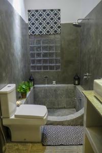 a bathroom with a tub and a toilet and a sink at Temple House Villa in Hikkaduwa +24 photos