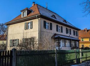 una casa vieja con una valla delante de ella en Holiday in quiet quarter, 20 min to city center, en Dresden