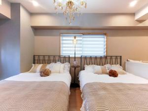 dos camas sentadas una al lado de la otra en un dormitorio en 15 西新宿区域 家庭式民宿- Nisjishinjuku area Max 6p, en Tokio