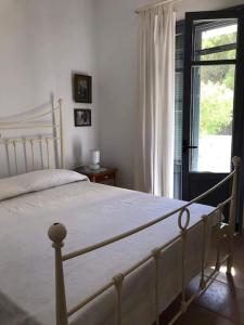 a white bed in a bedroom with a window at Semini Villa in Kalymnos