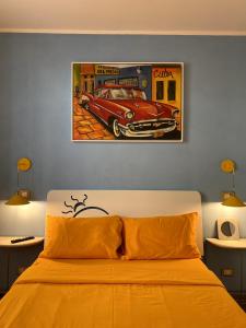 ein Schlafzimmer mit einem Bett und einem Gemälde eines Autos in der Unterkunft Residenza il palazzetto in Rom