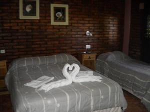 Posada de campo Mamúll Mapú في Rancul: وجود بجعتين على سرير في غرفة