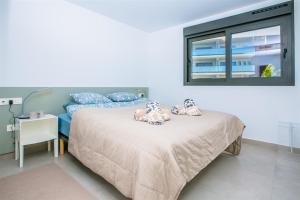 a bedroom with a bed with two stuffed animals on it at Prime Spanish Holidays - Arenal Dream in Jávea +16 photos