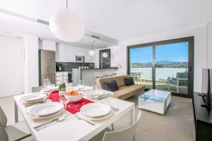 a dining room and kitchen with a white table and chairs at Prime Spanish Holidays - Arenal Dream in Jávea