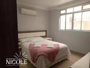 a bedroom with a bed with two towels on it at Residencial Nicole in Florianópolis