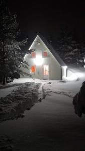 a house with a light on the side of it at night at Vikendica Mateo in Blidinje
