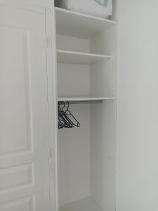 a white closet with white walls and shelves at Studio Vacances in Saint Malo