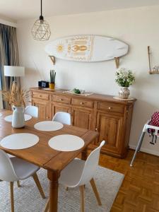 a dining room with a table and a surfboard on the wall at Katty apartment in Brussels