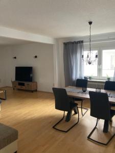 sala de estar con mesa, sillas y TV en Appartment Griesheim, en Griesheim